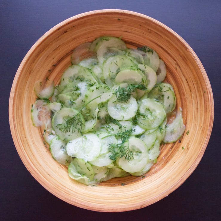 Wooden bowl with German cucumber dill salad (Gurkensalat)